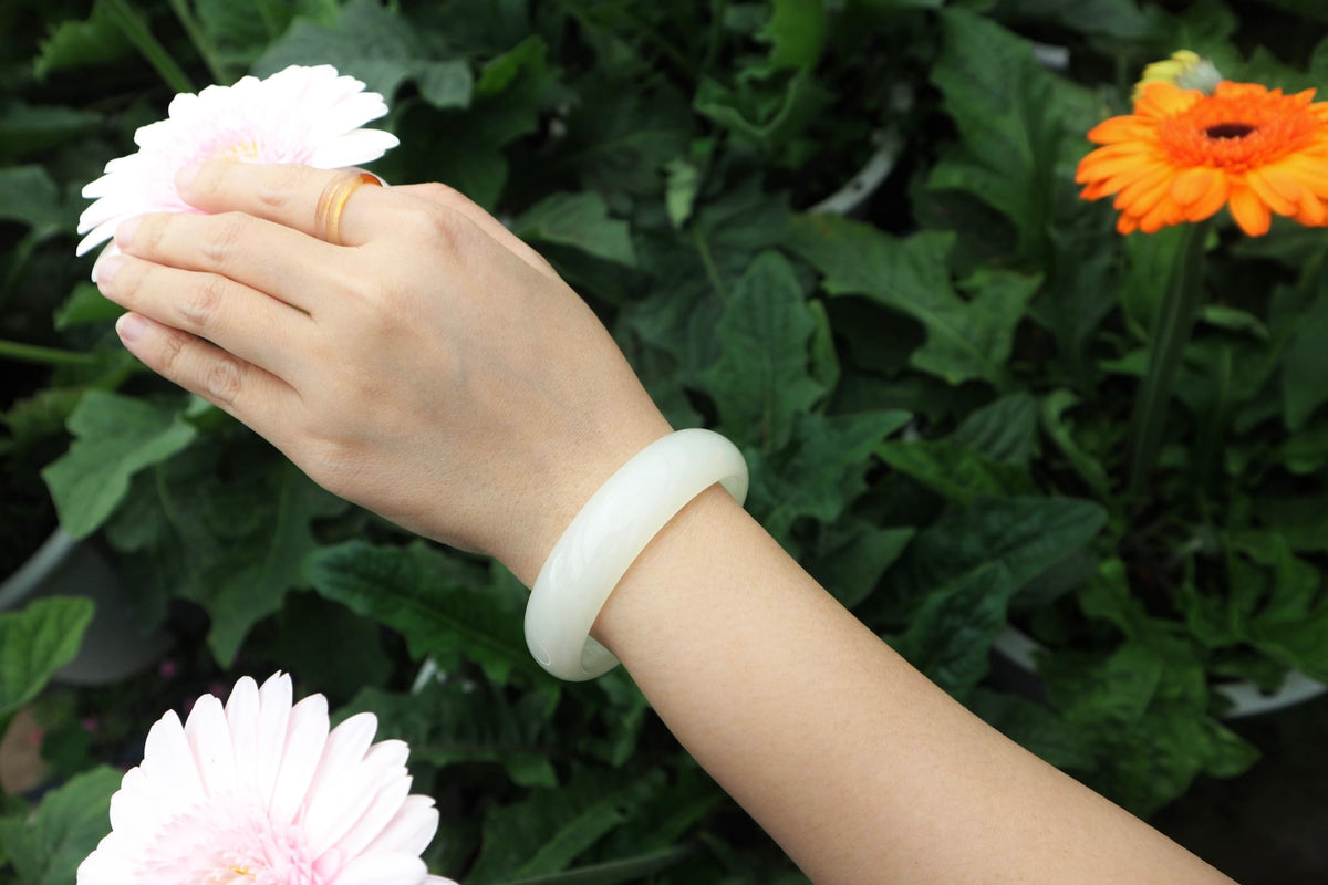 Woman wearing a polished green Jadeite bangle and ring