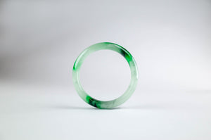green and white jade bangle on a white background